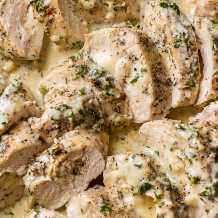 slices of chicken breast in a mozzarella cream sauce topped with herbs