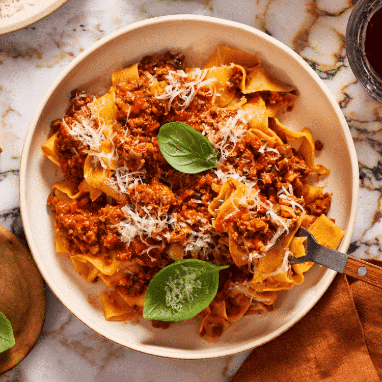 Featured image of pappardelle bolognese served in a bowl.