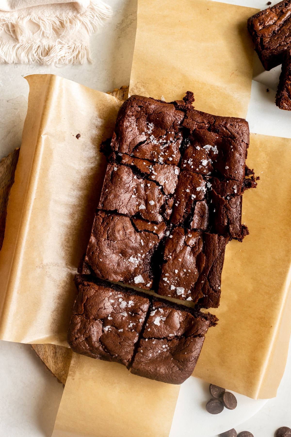 brownies on parchment paper garnished with flaky sea salt.