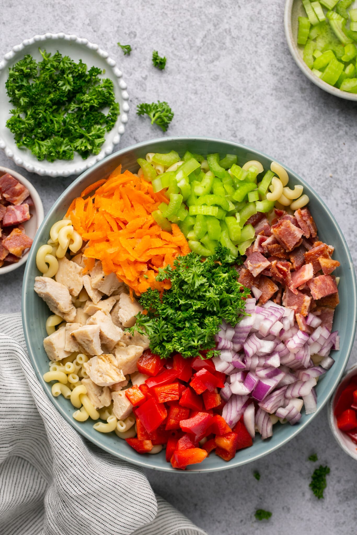 ingredients for macaroni salad in a large blue bowl.