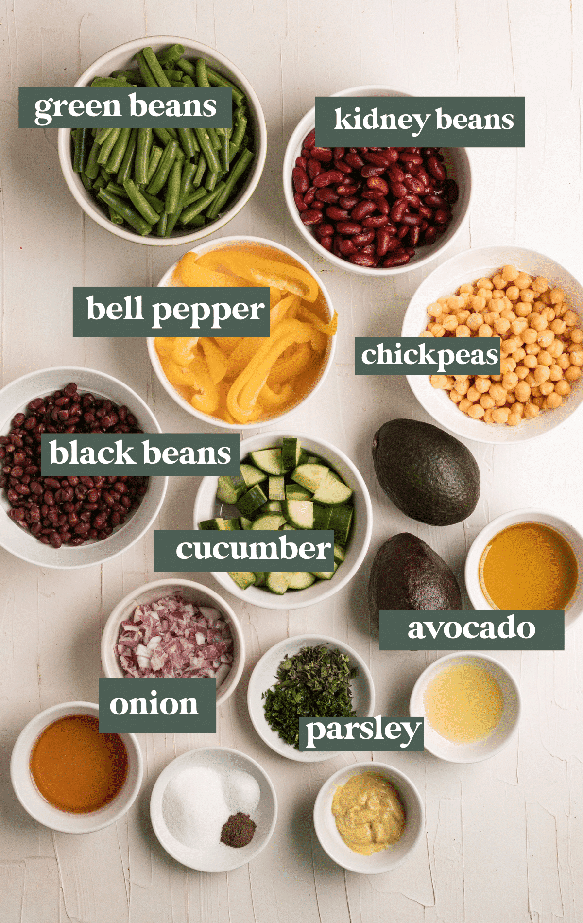 ingredients in small glass bowls needed to make bean salad. 