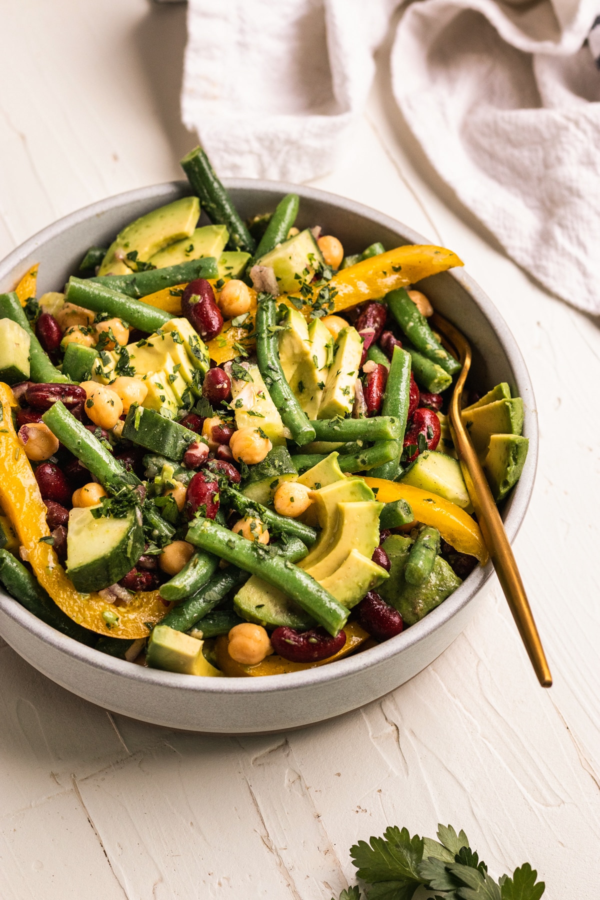 bean salad in a white bowl garnished with parsley. 