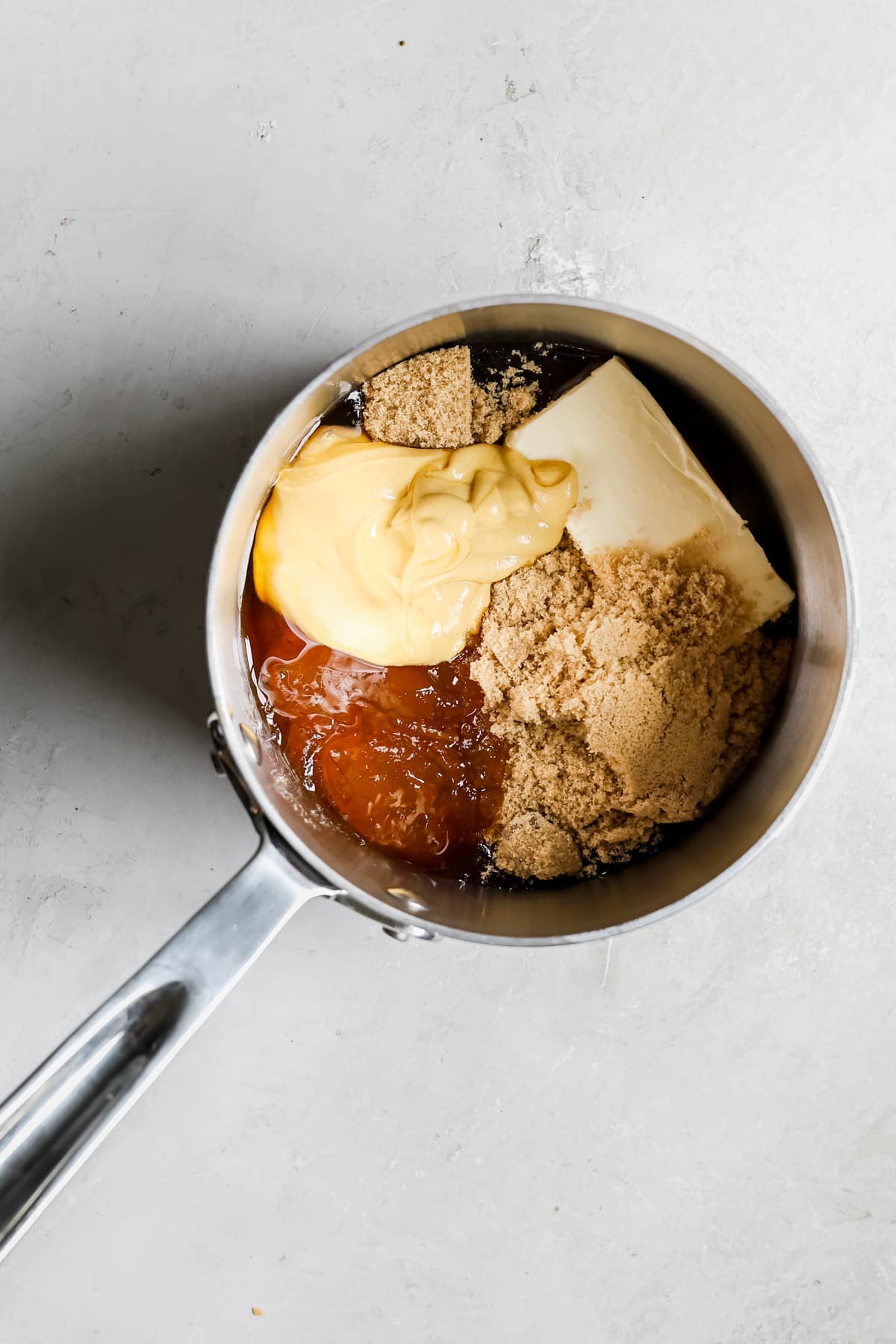 ingredients for a honey glaze in a stainless steel saucepan. 