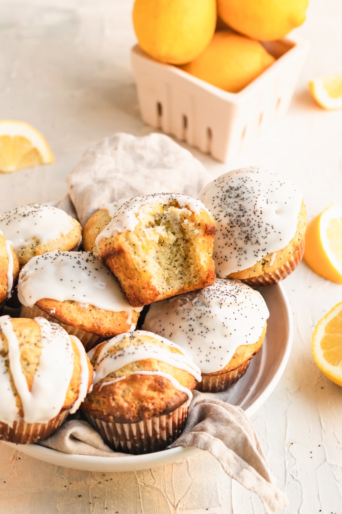 muffins in a bowl with glaze on top and poppyseeds.