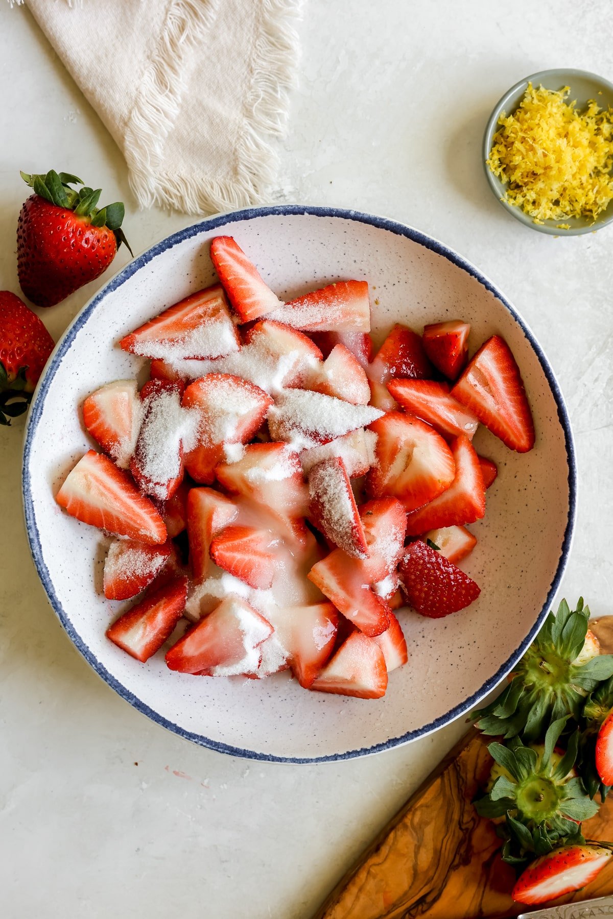 strawberries sliced in a bowl with sugar on top.