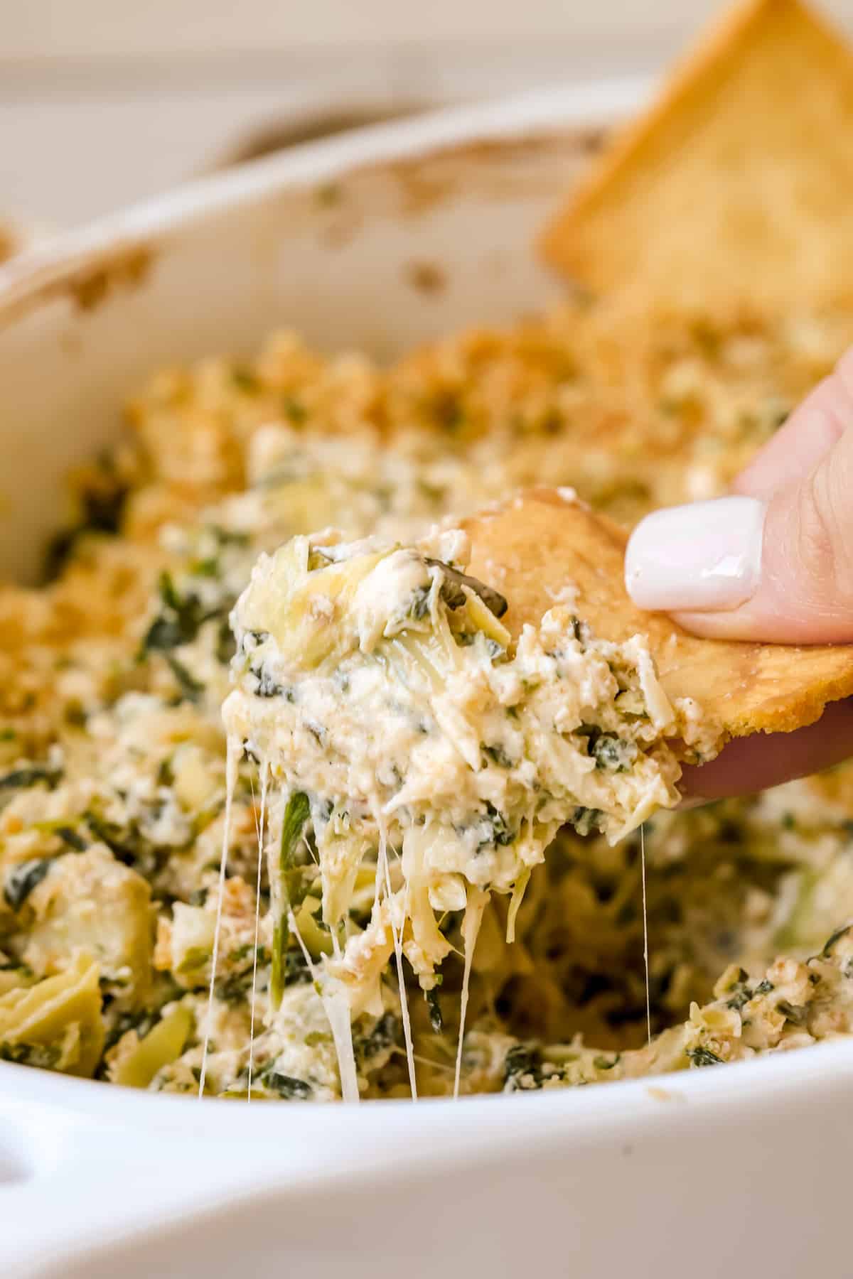 a chip dunking into a cheesy dip. 