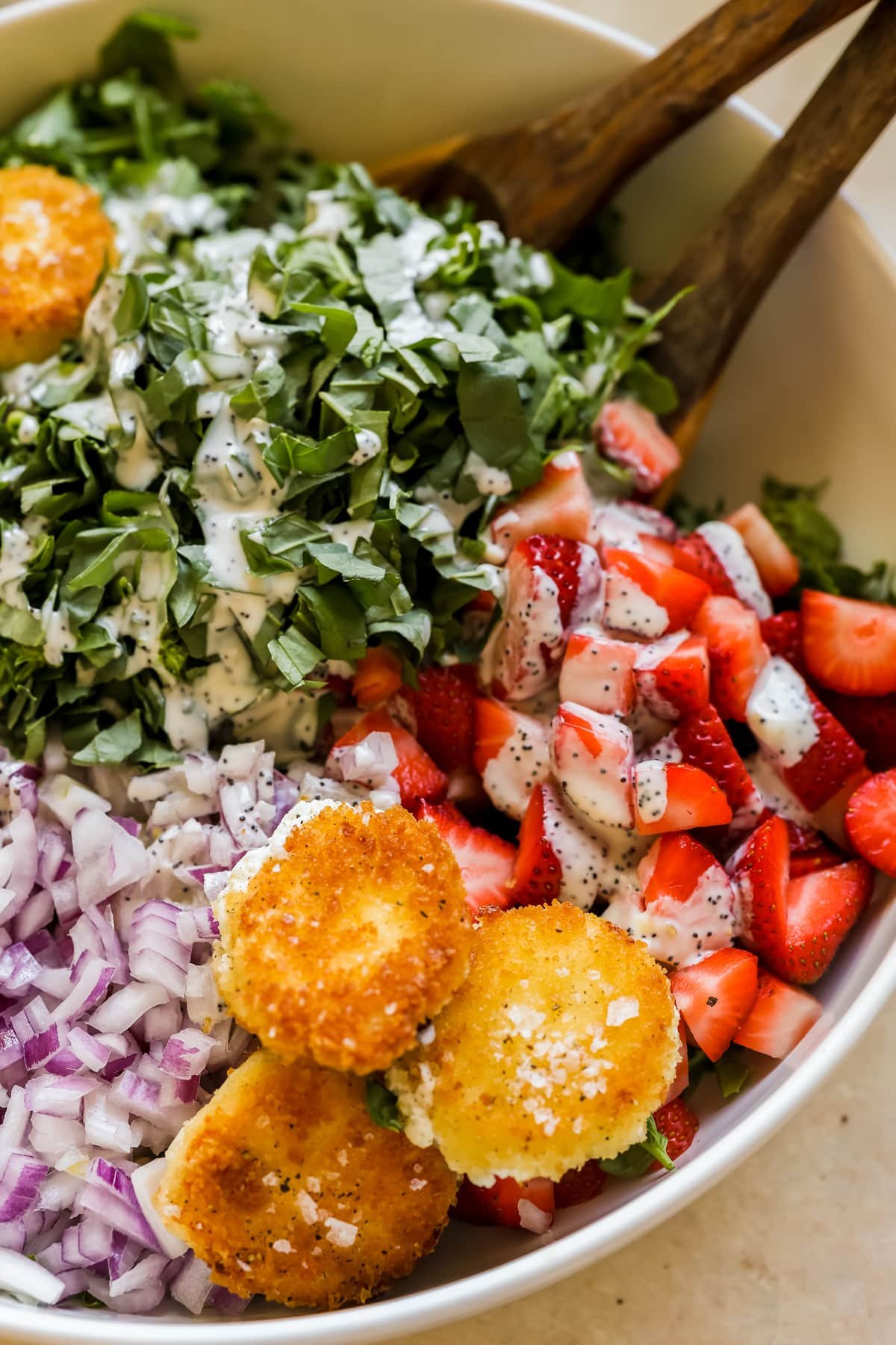 an up close image of a strawberry salad with fried goat cheese croutons.