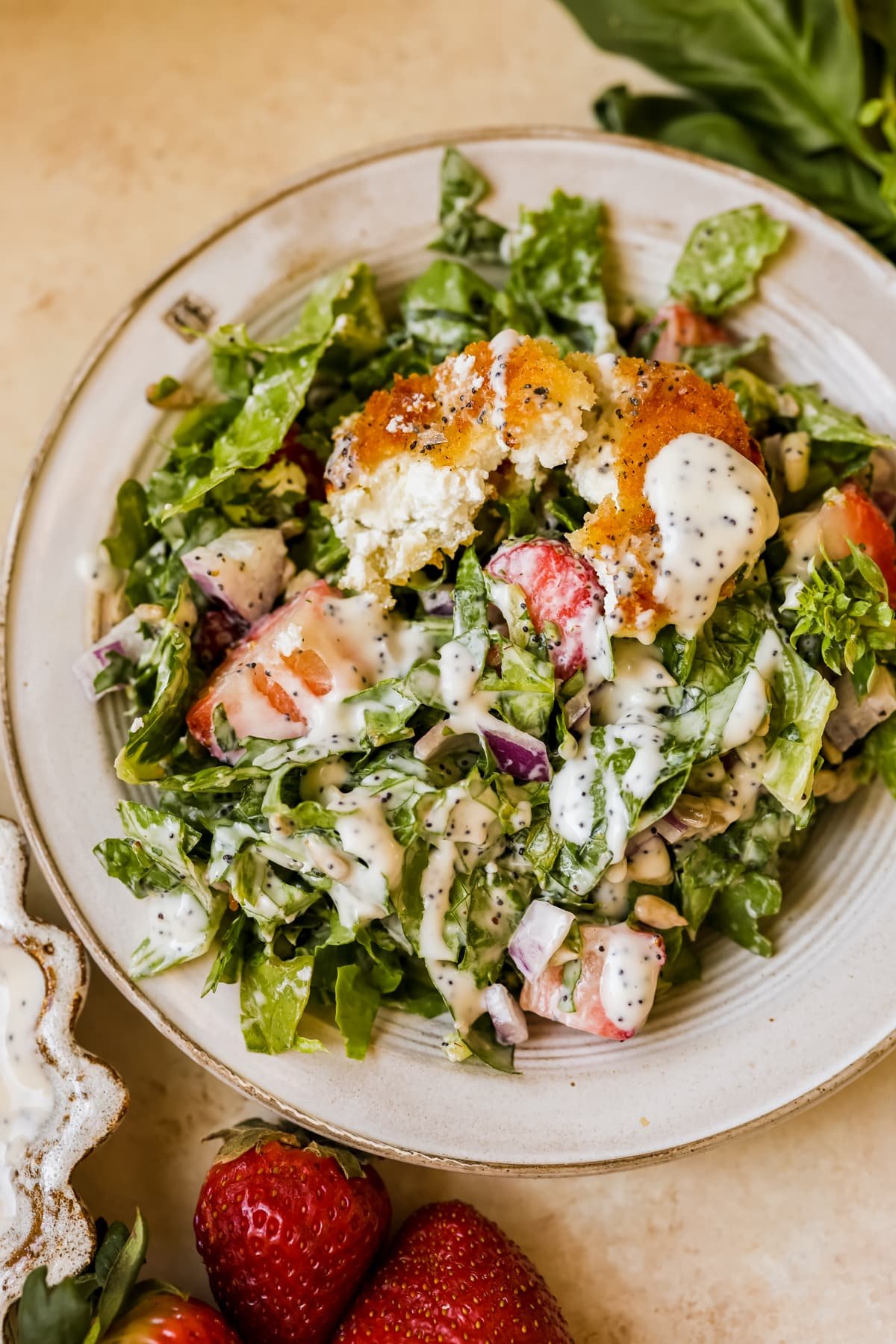salad on a plate with poppy seed dressing and fried goat cheese. 