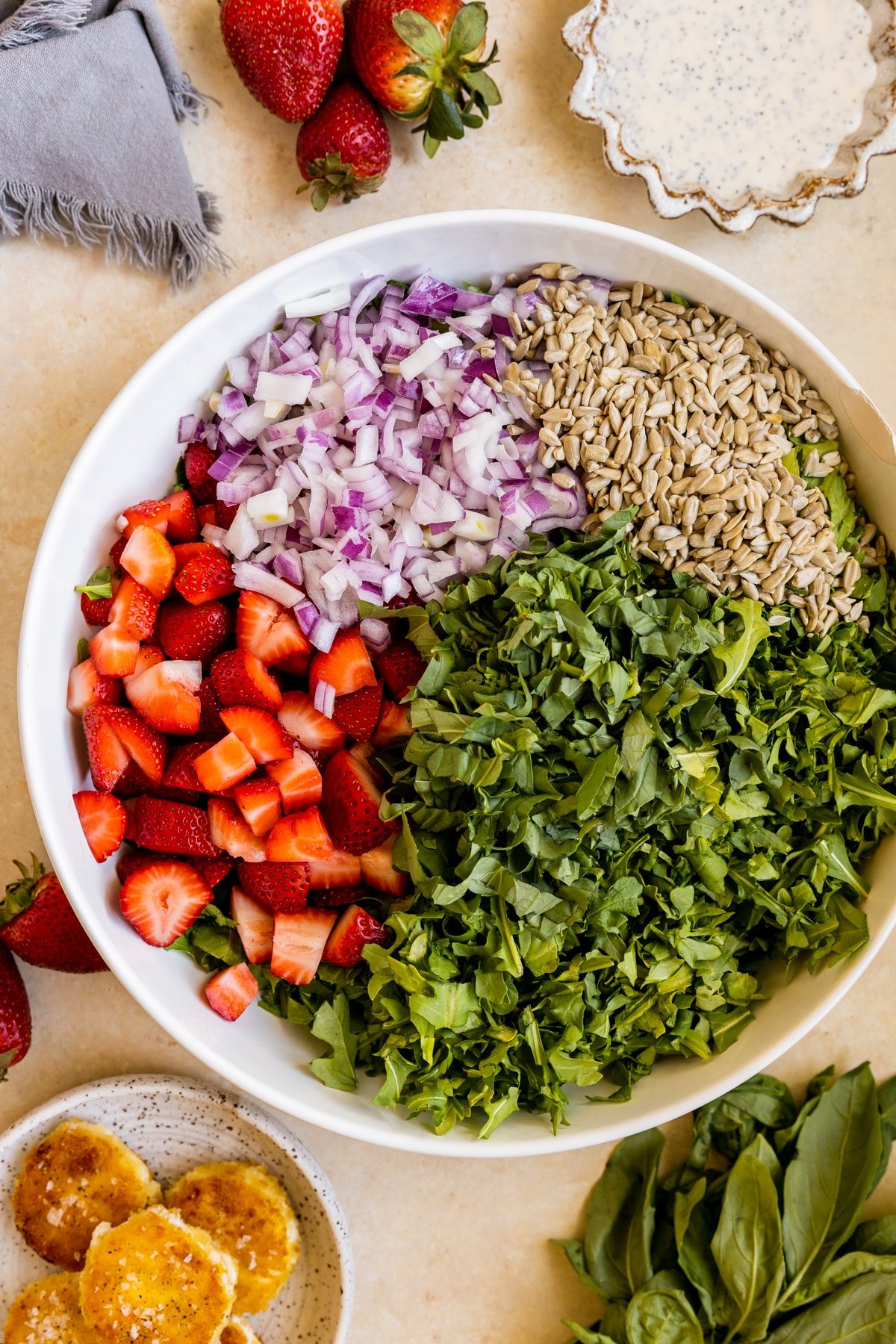 romaine lettuce, strawberries, sun flower seeds and onions in a large white salad bowl. 