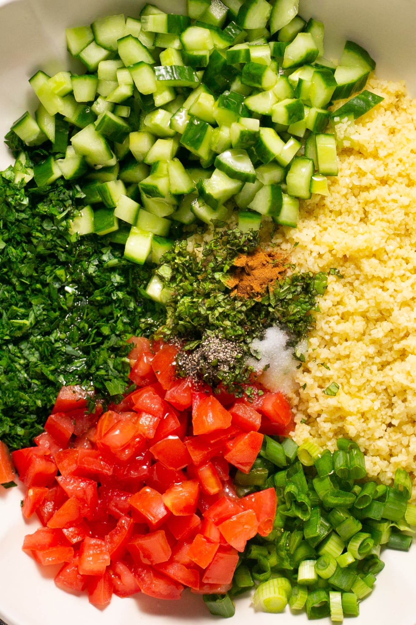 fresh ingredients for bulgur salad in a mixing bowl.
