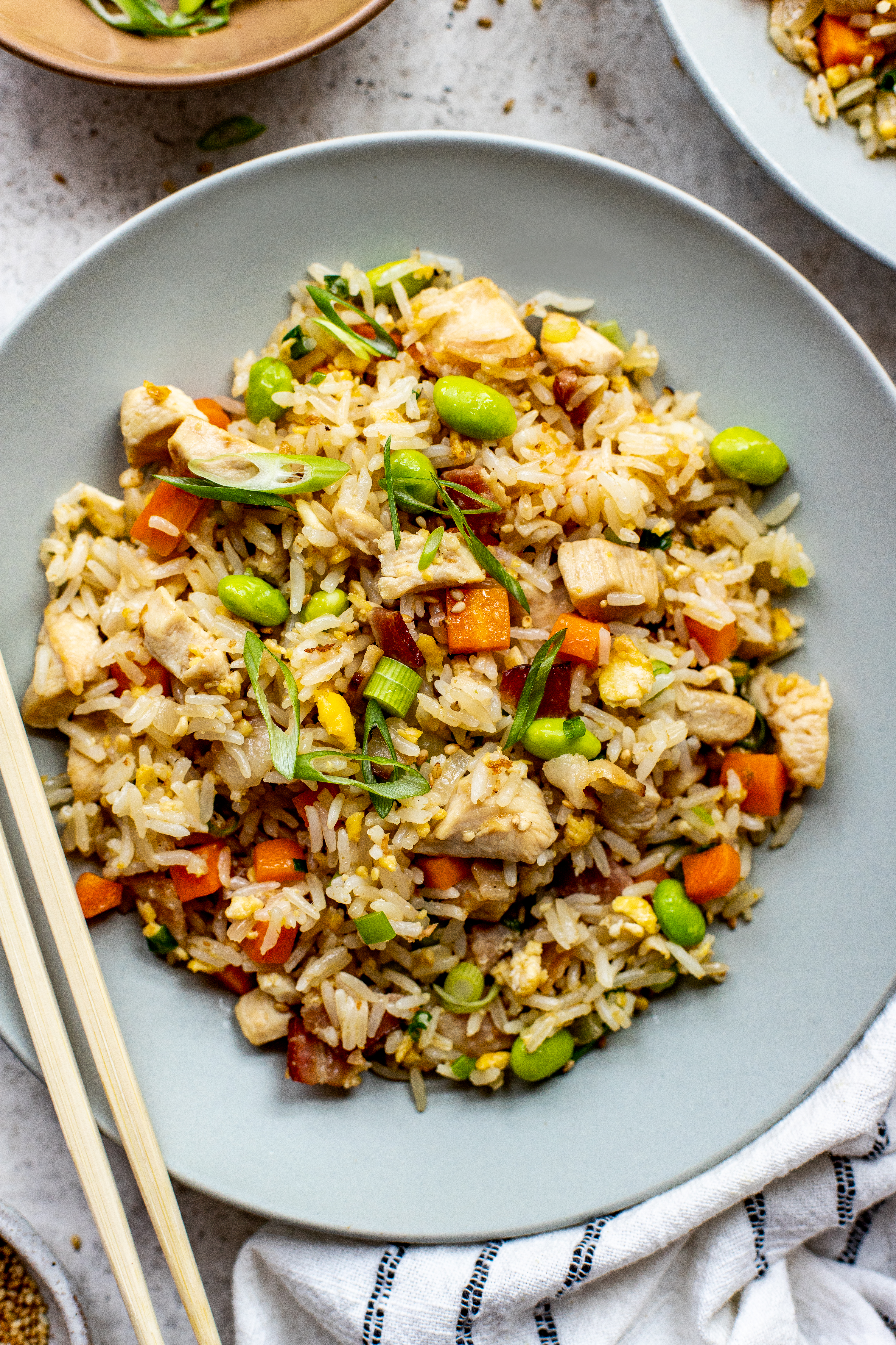 fried rice in a bowl with chopsticks on the side. 