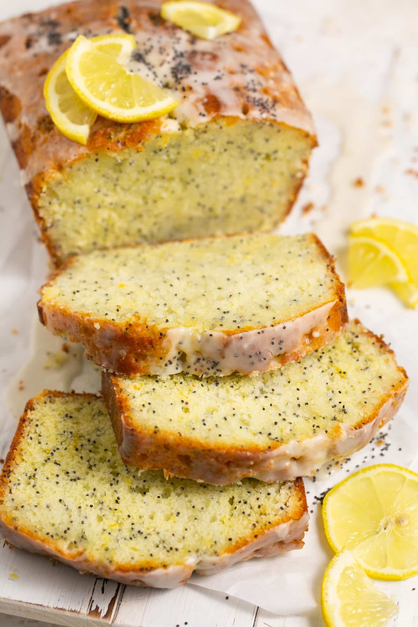 sliced lemon poppyseed cake drizzled with a lemon glaze on top.