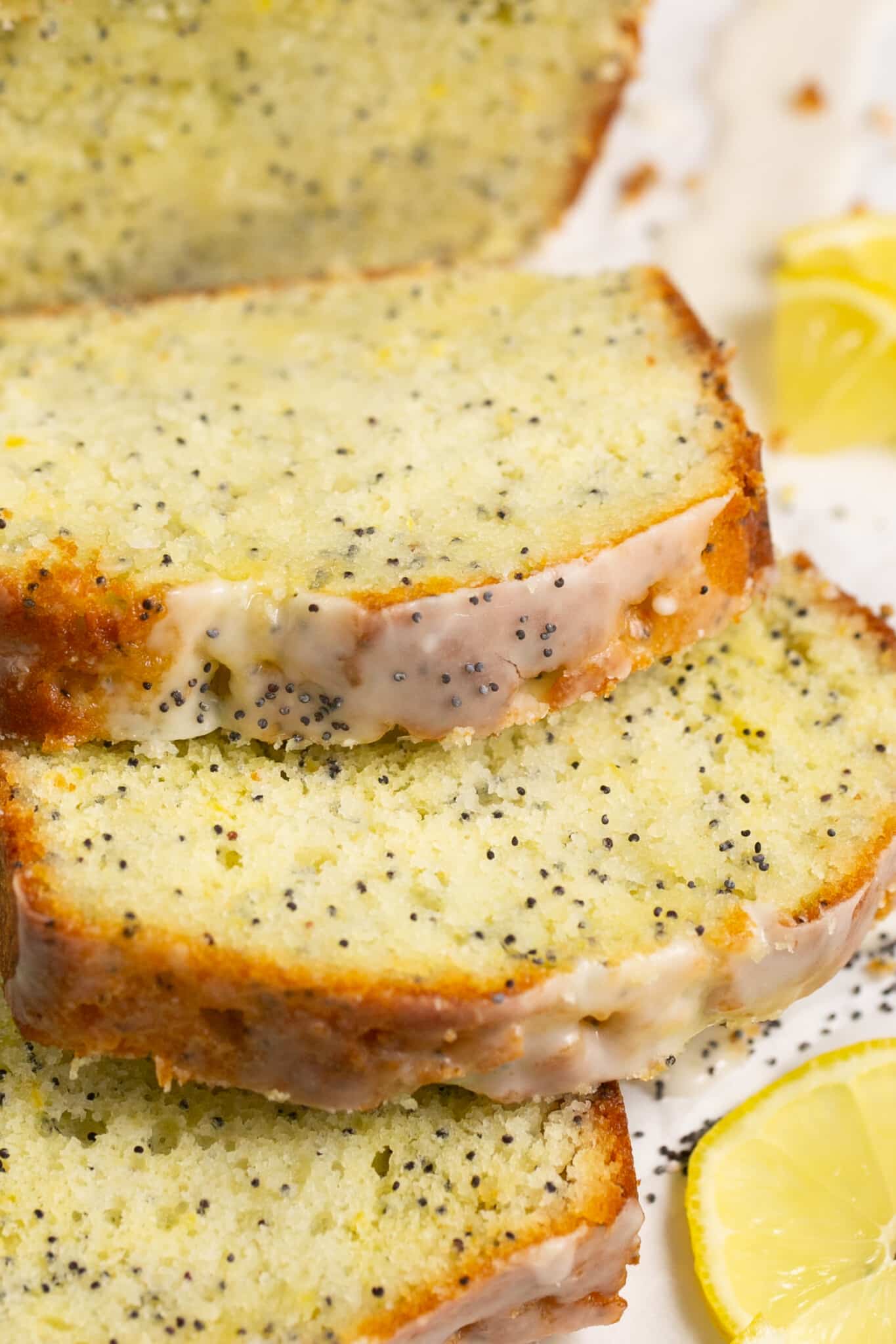 an up close image of sliced lemon cake with poppyseeds. 