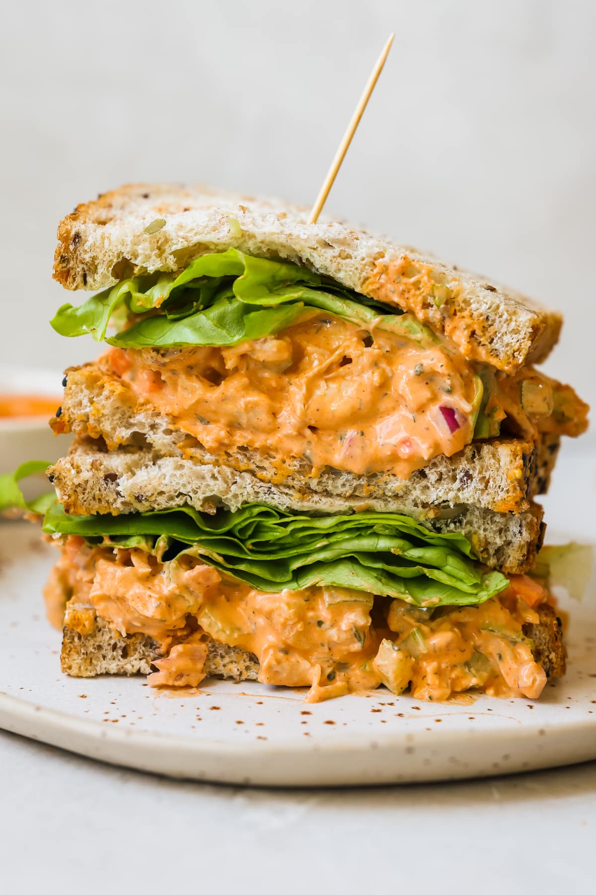 buffalo chicken sandwich with lettuce on a white speckled plate. 
