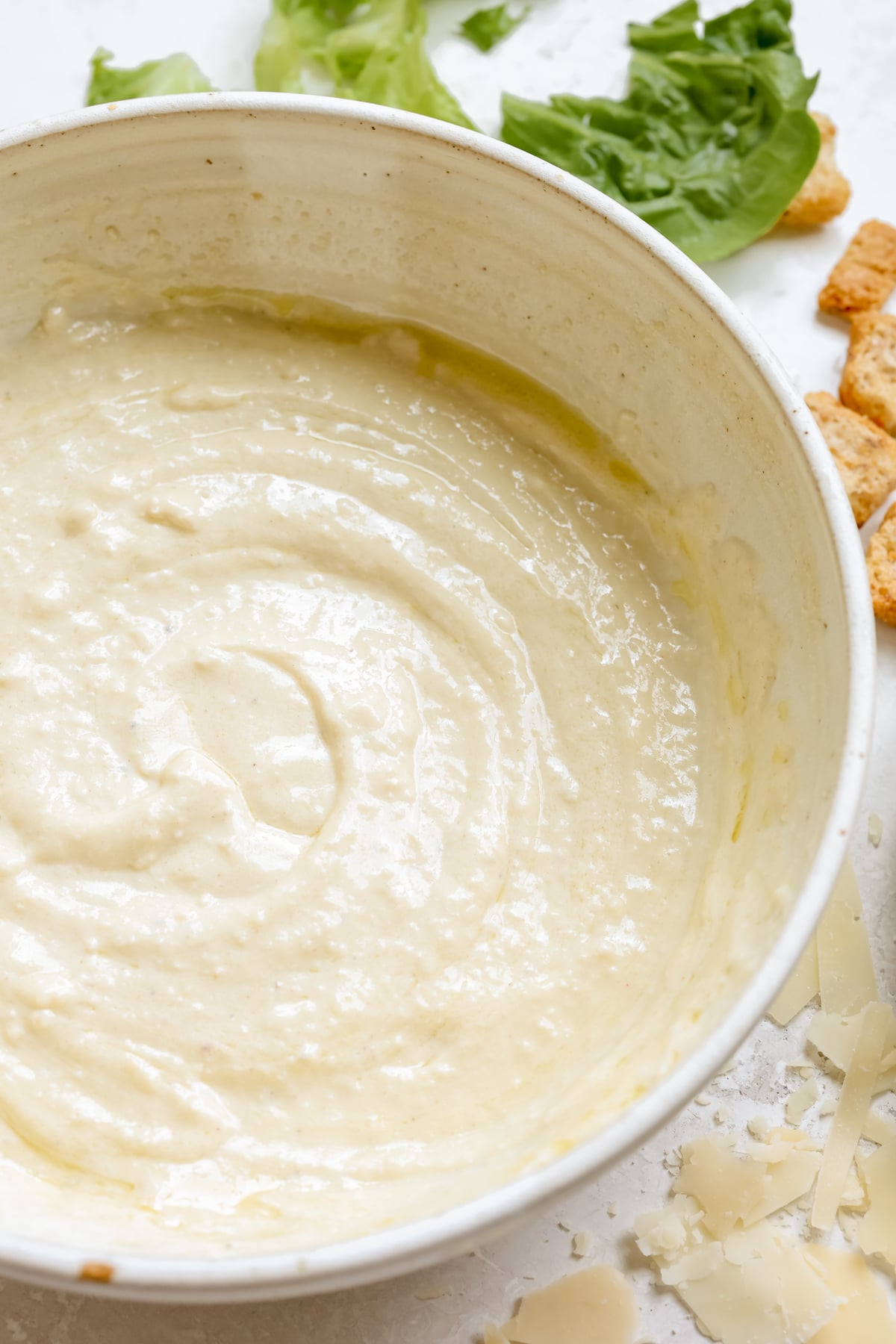 homemade caesar dressing in a white bowl.