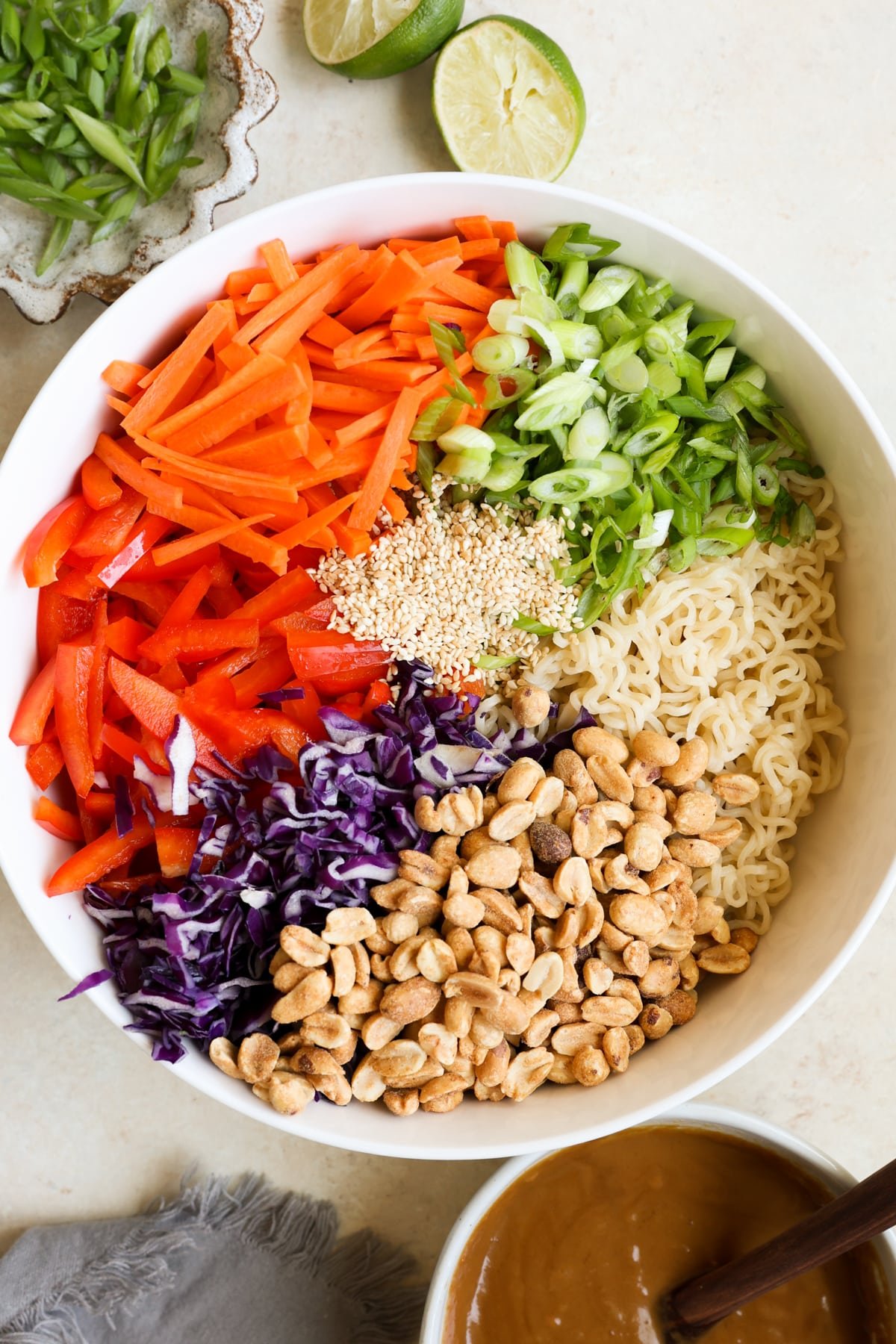 ingredients to make noodle salad in a large white bowl. 