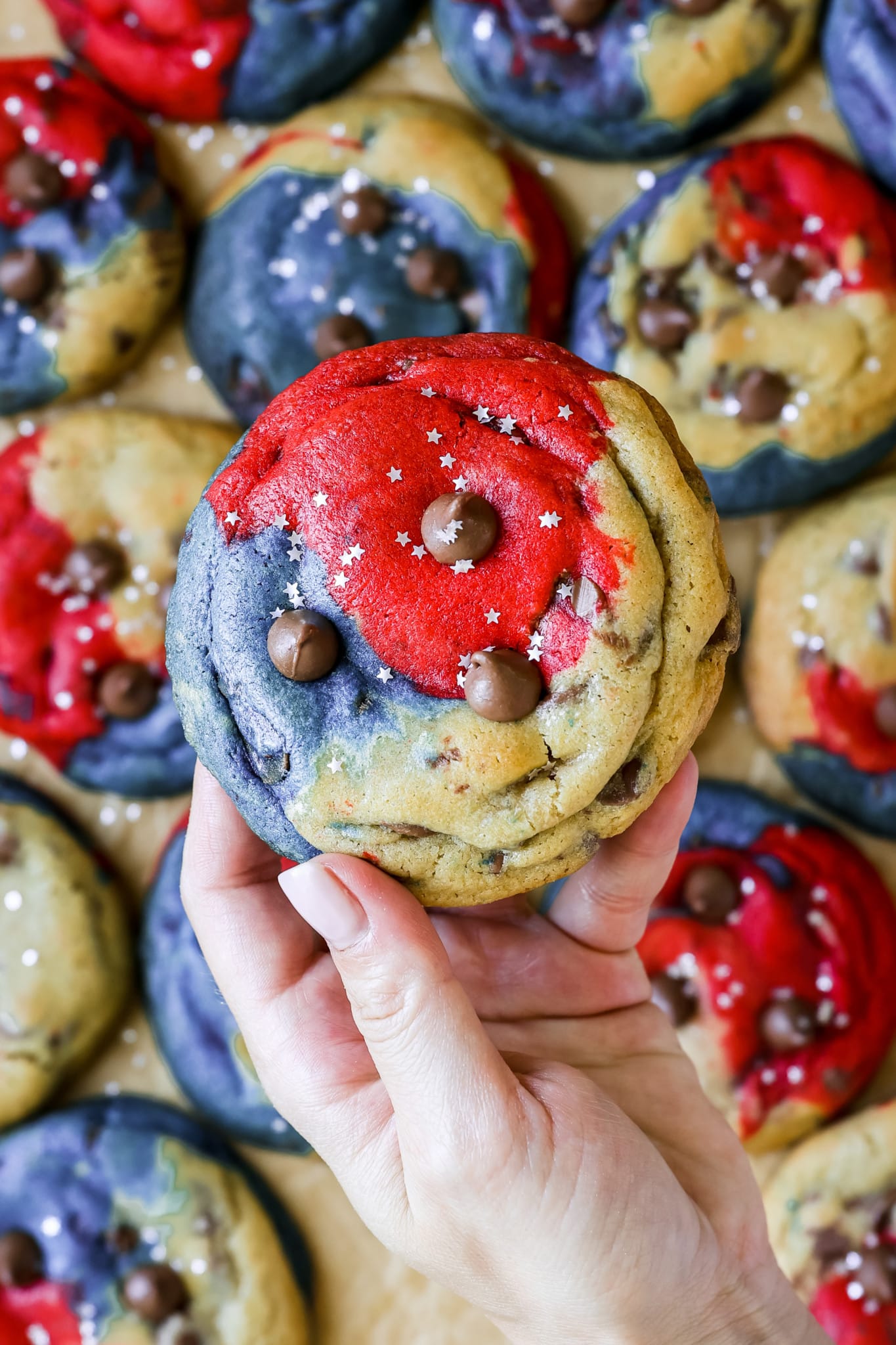 a womans hand holding a 4th of july cookie.