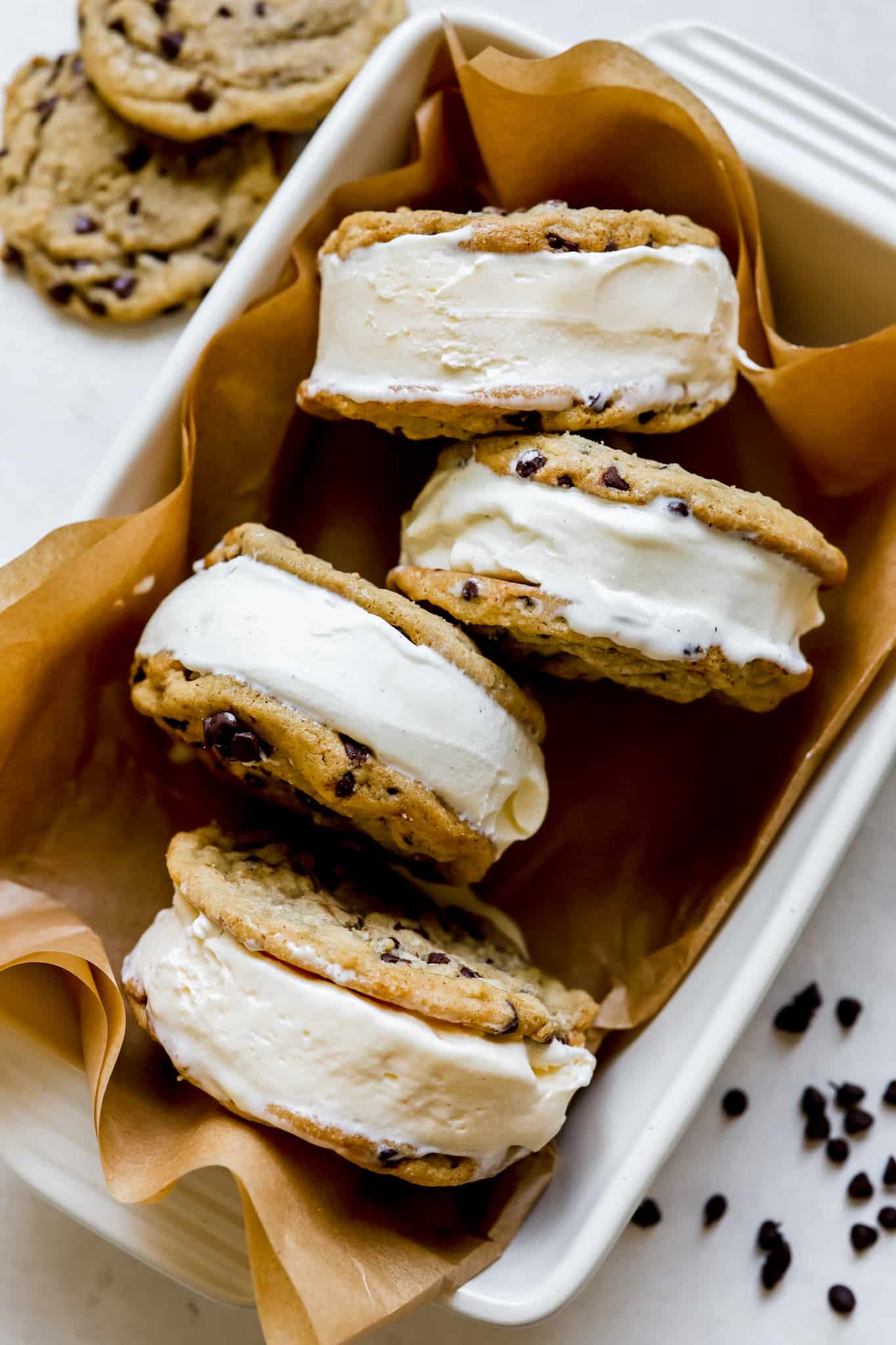 ice cream sandwiches with chocolate chip cookies on parchment paper. 