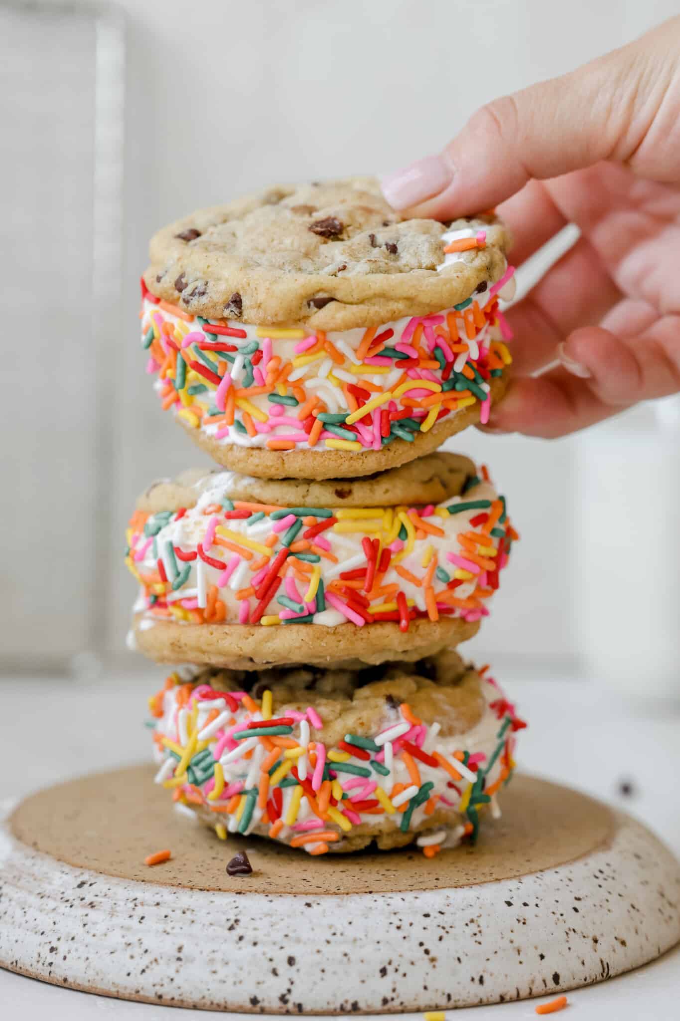 a stack of ice cream cookie sandwiches with rainbow sprinkles. 