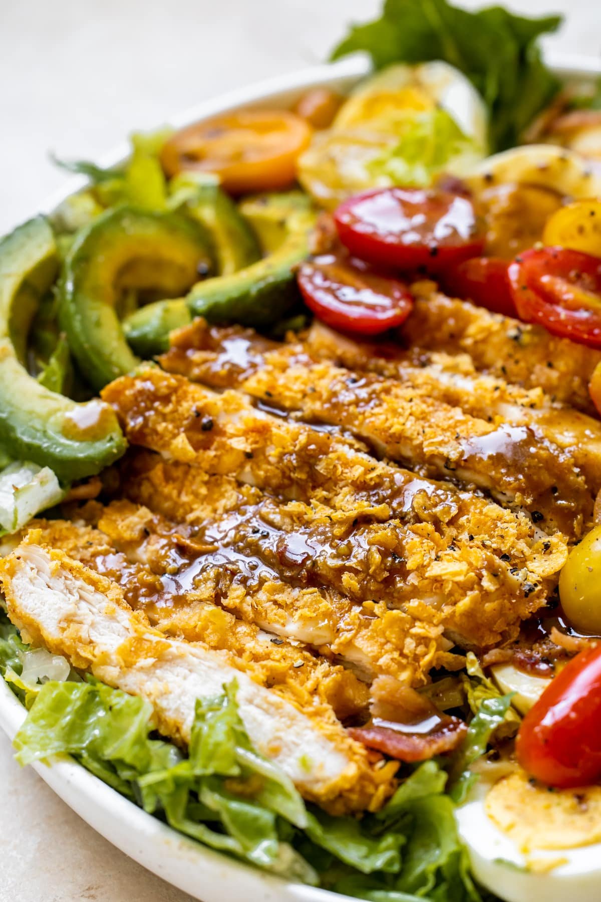 an up close image on balsamic dressing on crispy chicken on a salad. 