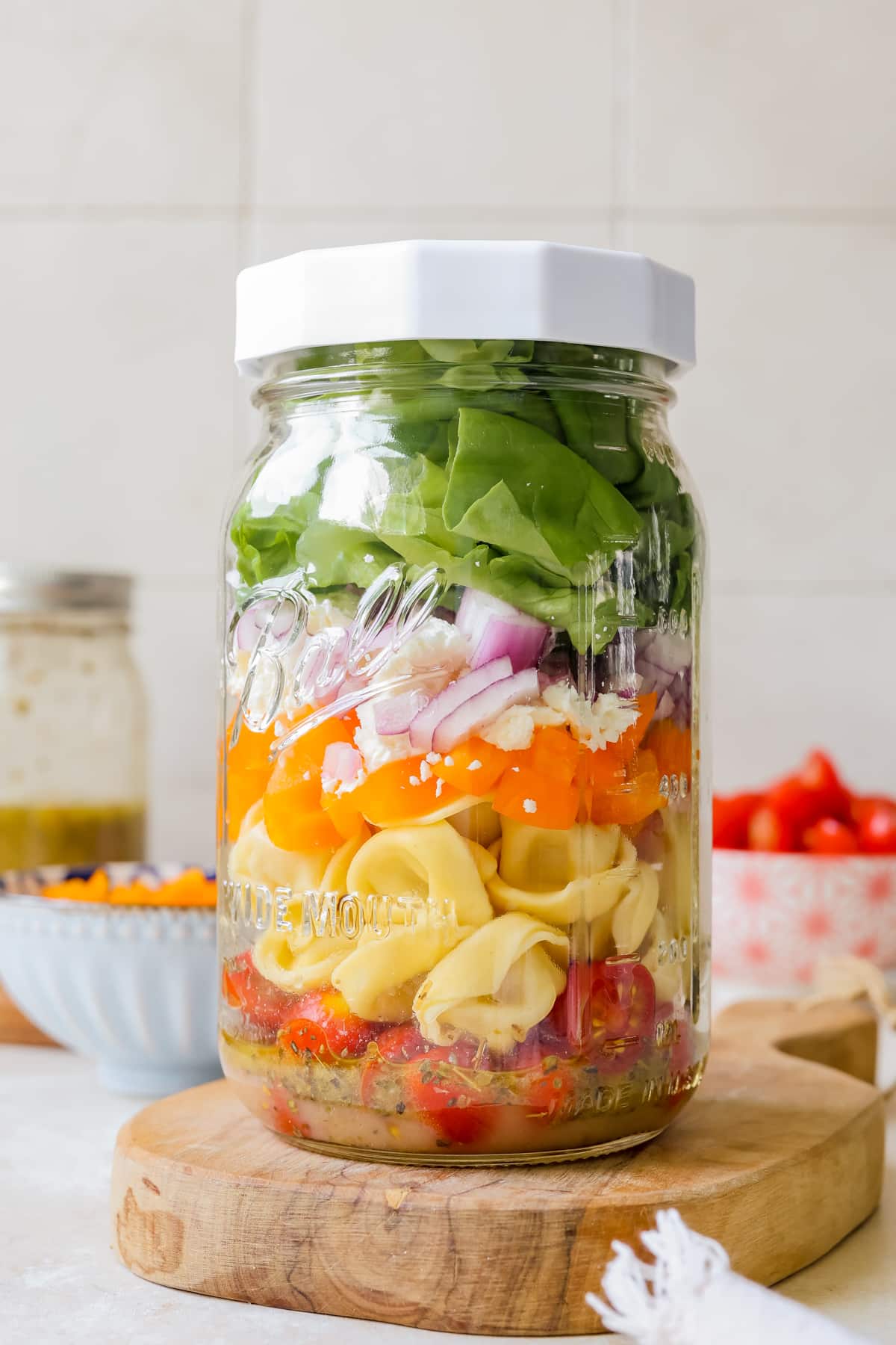 salad in a mason jar with a white lid on the jar. 