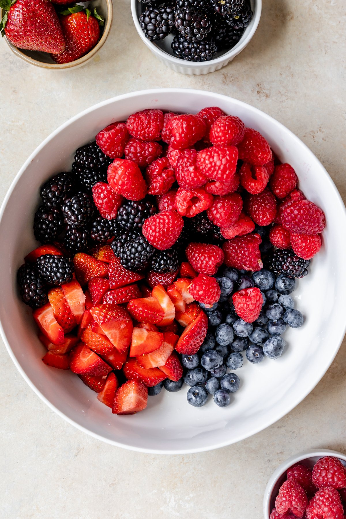 raspberries, blackberries, strawberries and blueberries in a large white bowl.