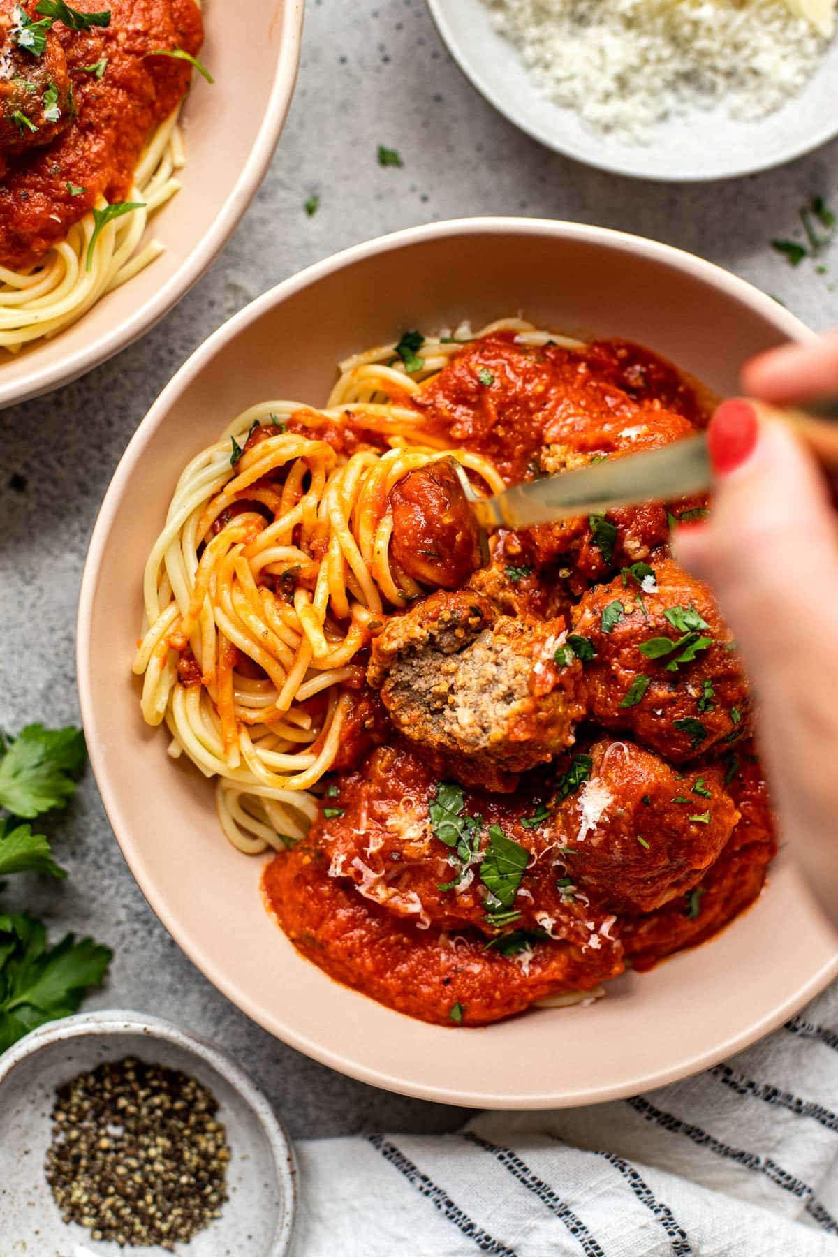 Spaghetti and meatballs in a bowl with a fork twirling the spaghetti. 