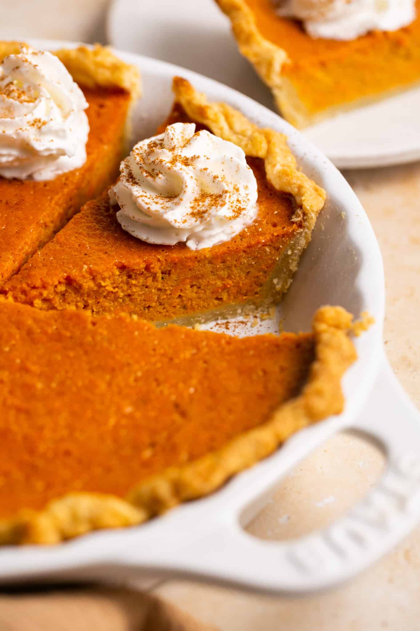A baked sweet potato pie with whipped cream on top. 
