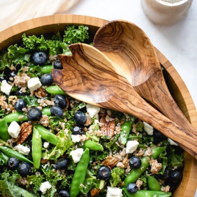wooden bowl with berry salad and wooden spoons