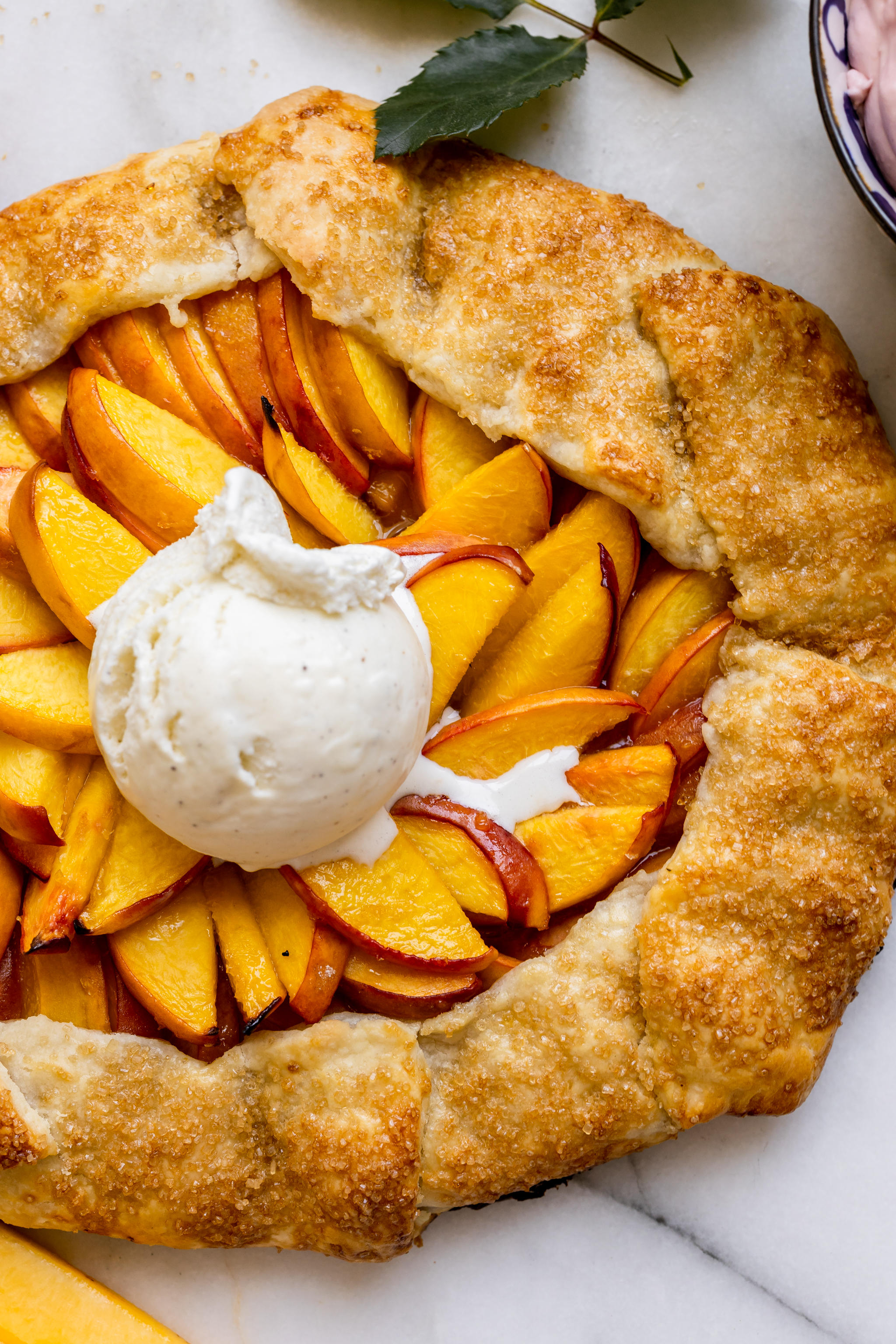 a freshly baked peach galette topped with vanilla ice cream. 