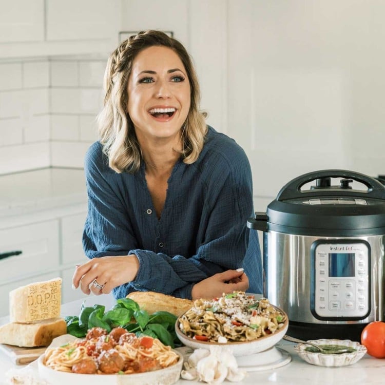 blogger tawnie graham in a kitchen with an instant pot and several dishes of food