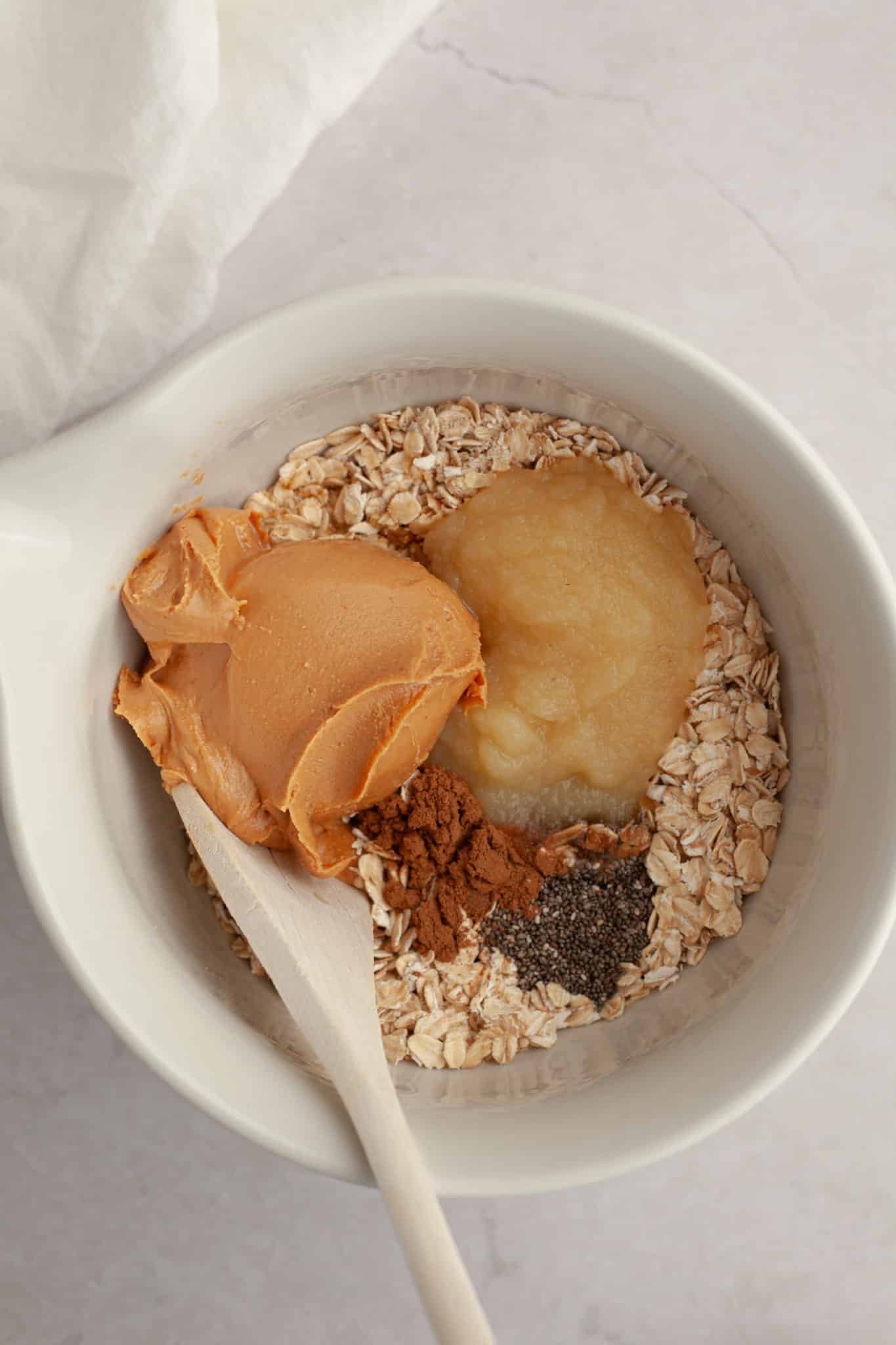 oats, peanut butter, and applesauce in a glass mixing bowl.
