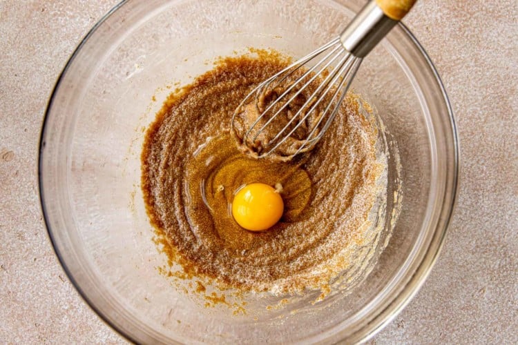 egg being whisked into a bowl of cookie batter