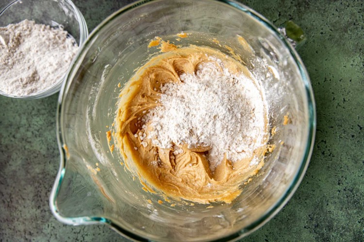 adding powdered ingredients to cookie dough mixture
