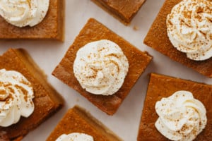 overhead shot of pumpkin pie bar squares with dollop of whipped cream