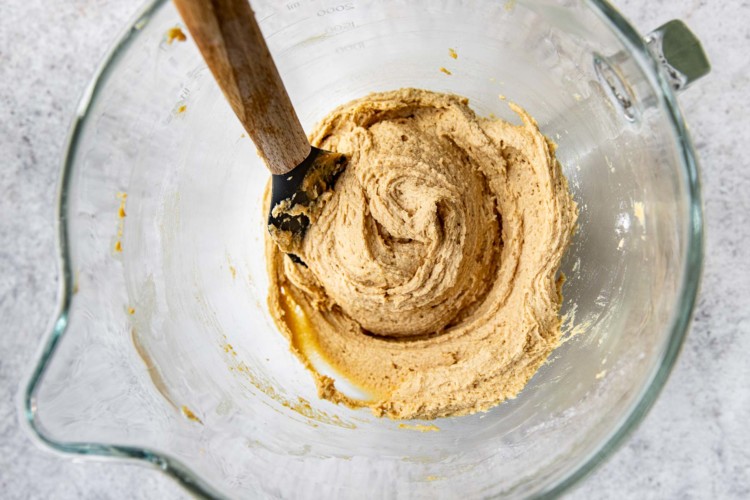 a wooden spoon stirring peanut butter cookie batter