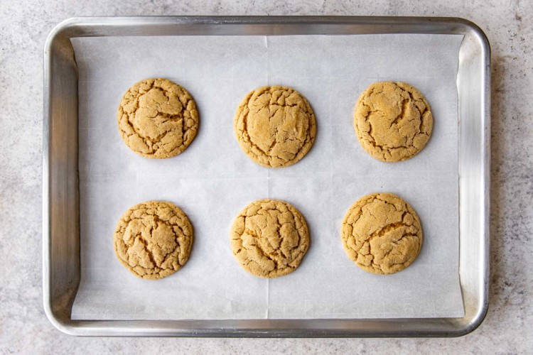 six peanut butter cookies on a baking sheet