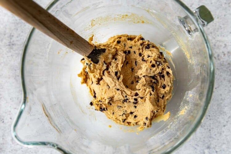 spoon stirring fluffernutter cookie dough in a clear bowl