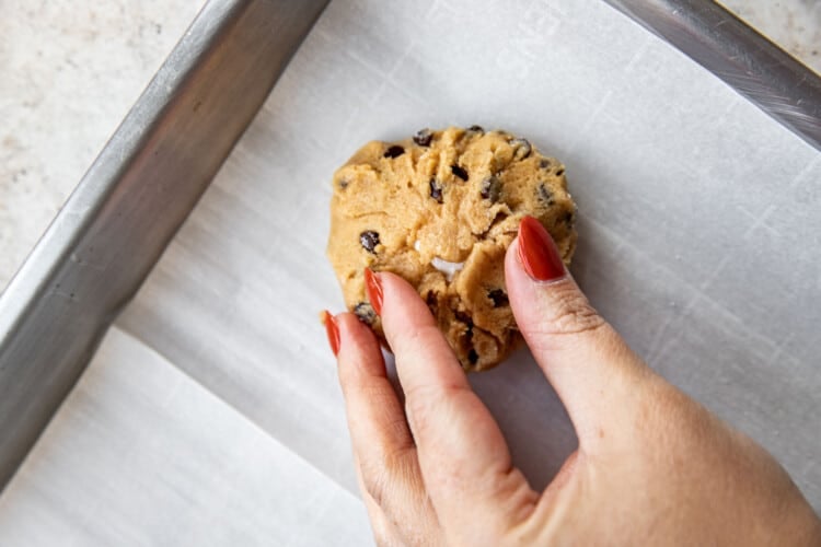 woman's hands pinching fluffernutter cookie dough on parchment paper