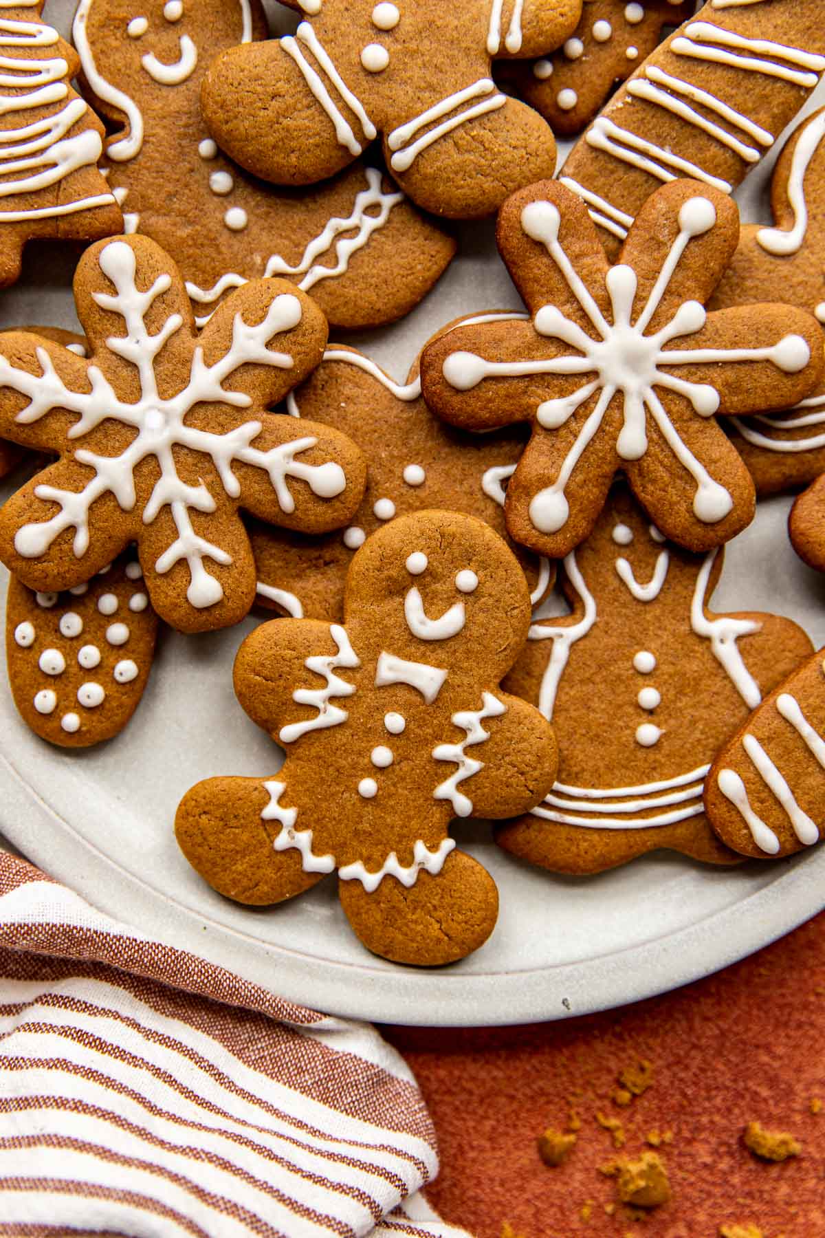 gingerbread man cookies on a piece of white parchment paper decorated with icing. 