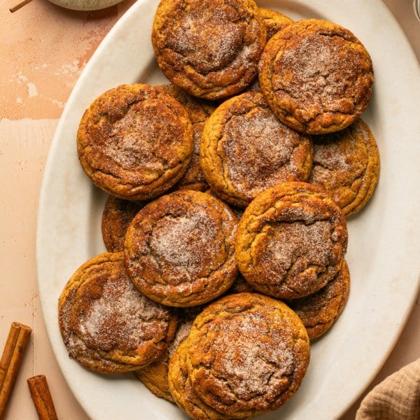 a white oval plate with gingerbread snickerdoodle cookies topped with cinnamon sugar