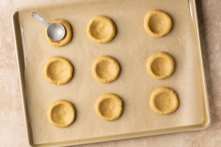 nine circles of cookie dough with cookie scoop imprint