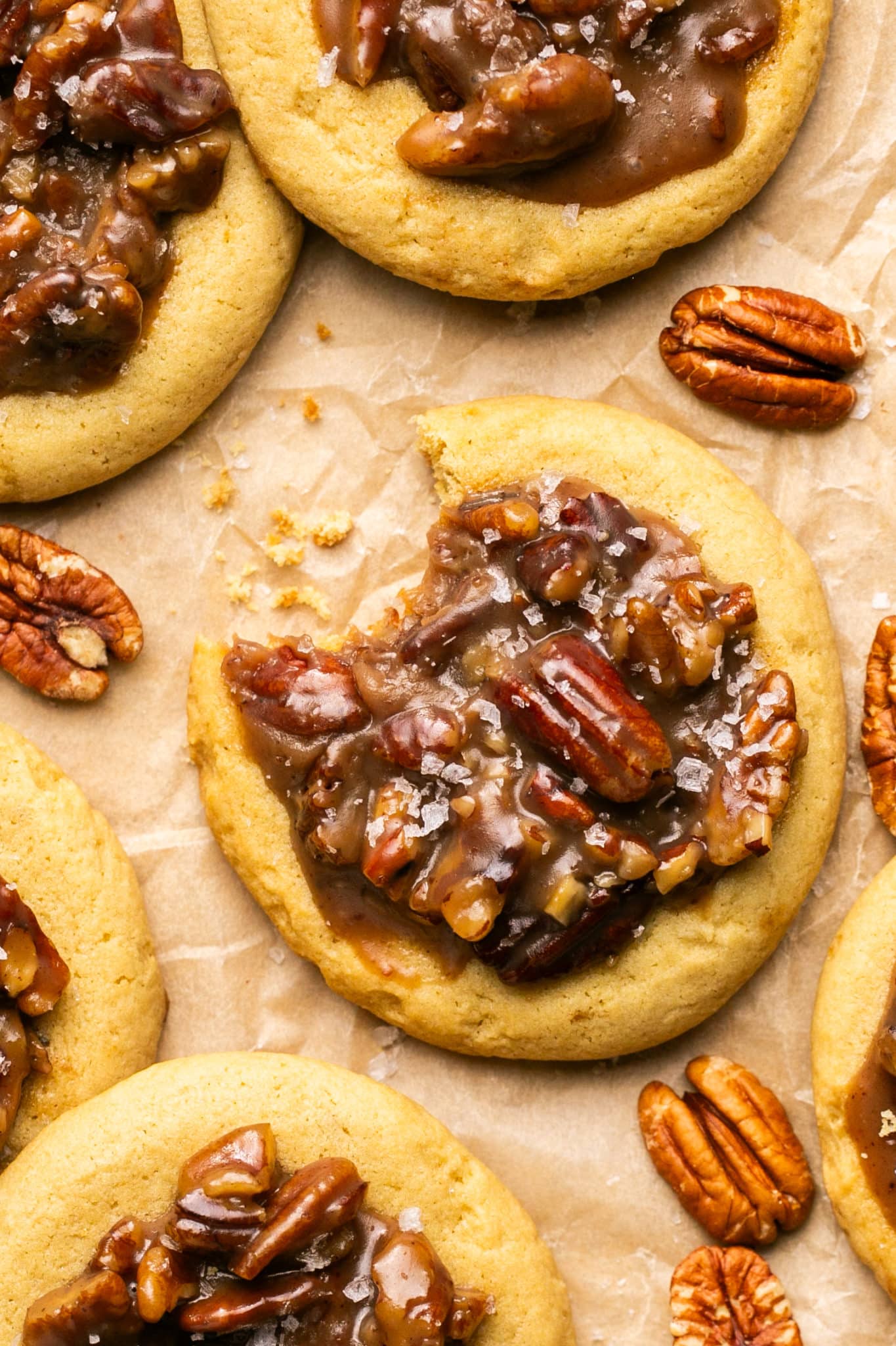 an up close image of pecan pie cookies with a bite taken out of one of the cookies. 