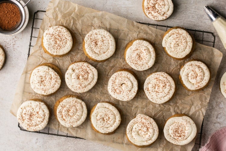 multiple tiramisu cookies with swirled icing on parchment paper