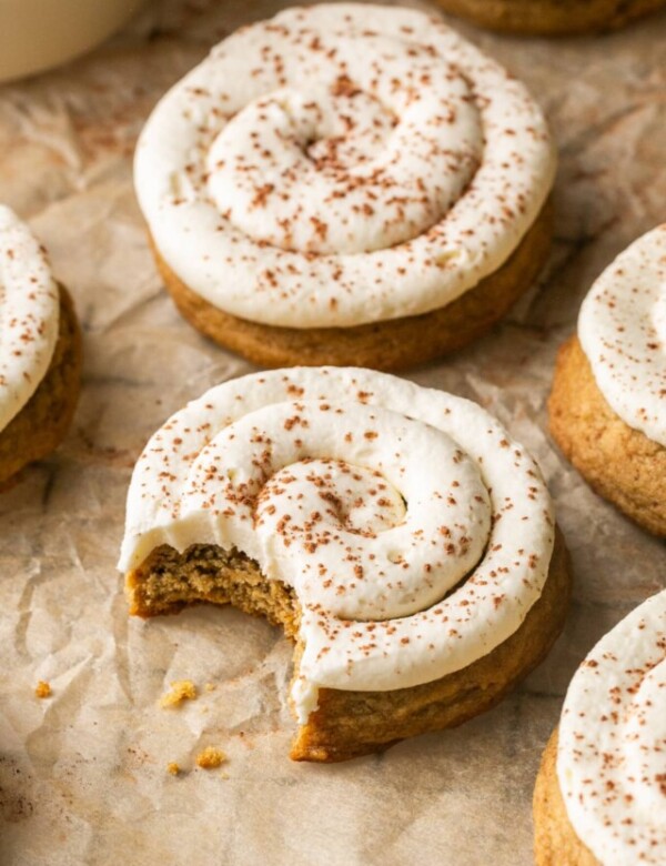 tiramisu cookies with white icing with a bite taken out 