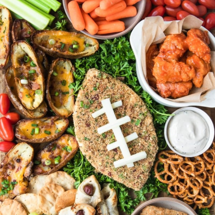plate with football shaped cheese surrounded by appetizers