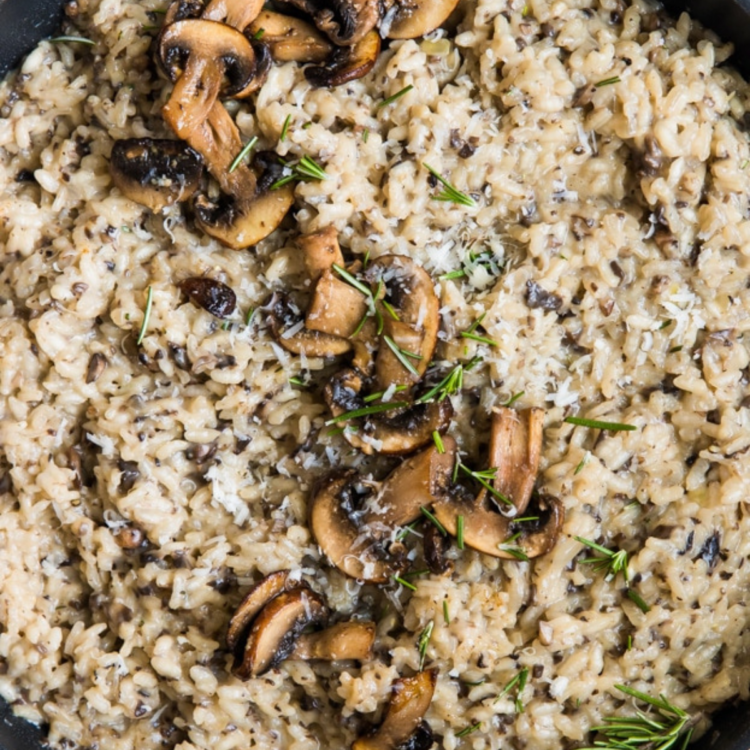 cast iron skilled with rice, sliced mushrooms, and herbs