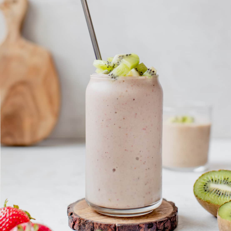 light pink smoothie topped with kiwi and a metal straw