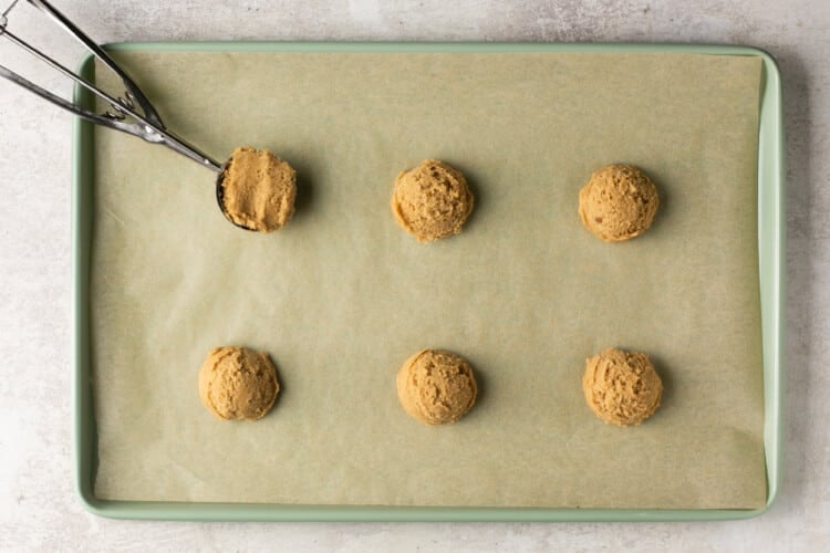 six balls of unbaked cookie dough on a shset