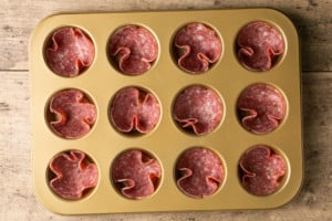 muffin tin with salami in each